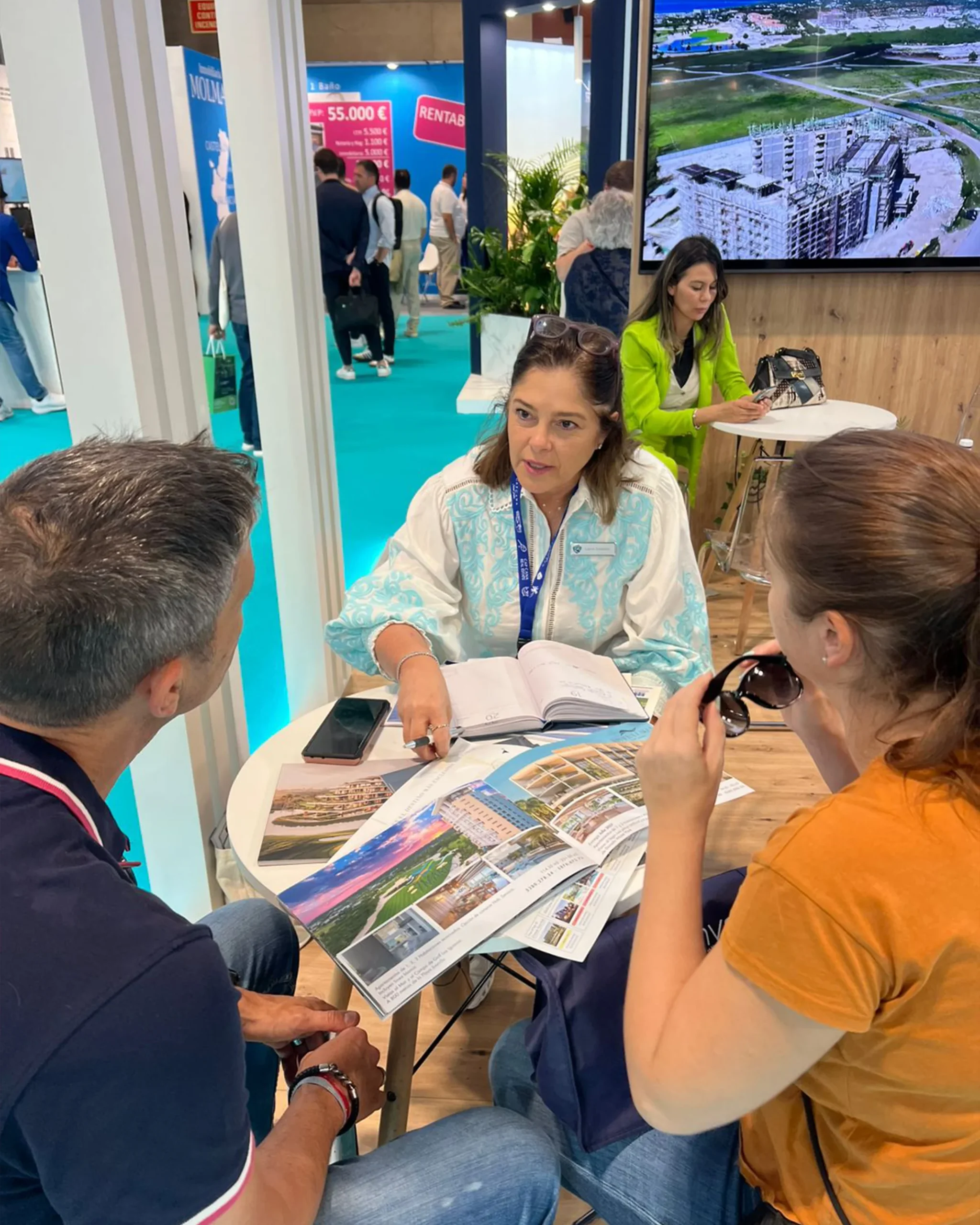 Asesora de LARE conversando con visitantes durante una feria inmobiliaria